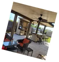 Covered patio with ceiling fan, wicker chairs and outdoor bar seating