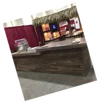 Showroom BBQ island bar with palm thatch roof and wood panel base