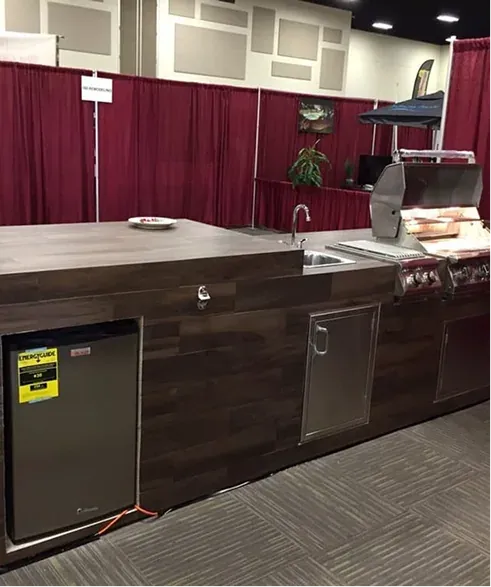 Showroom BBQ island in dark wood finish with sink, fridge and grill